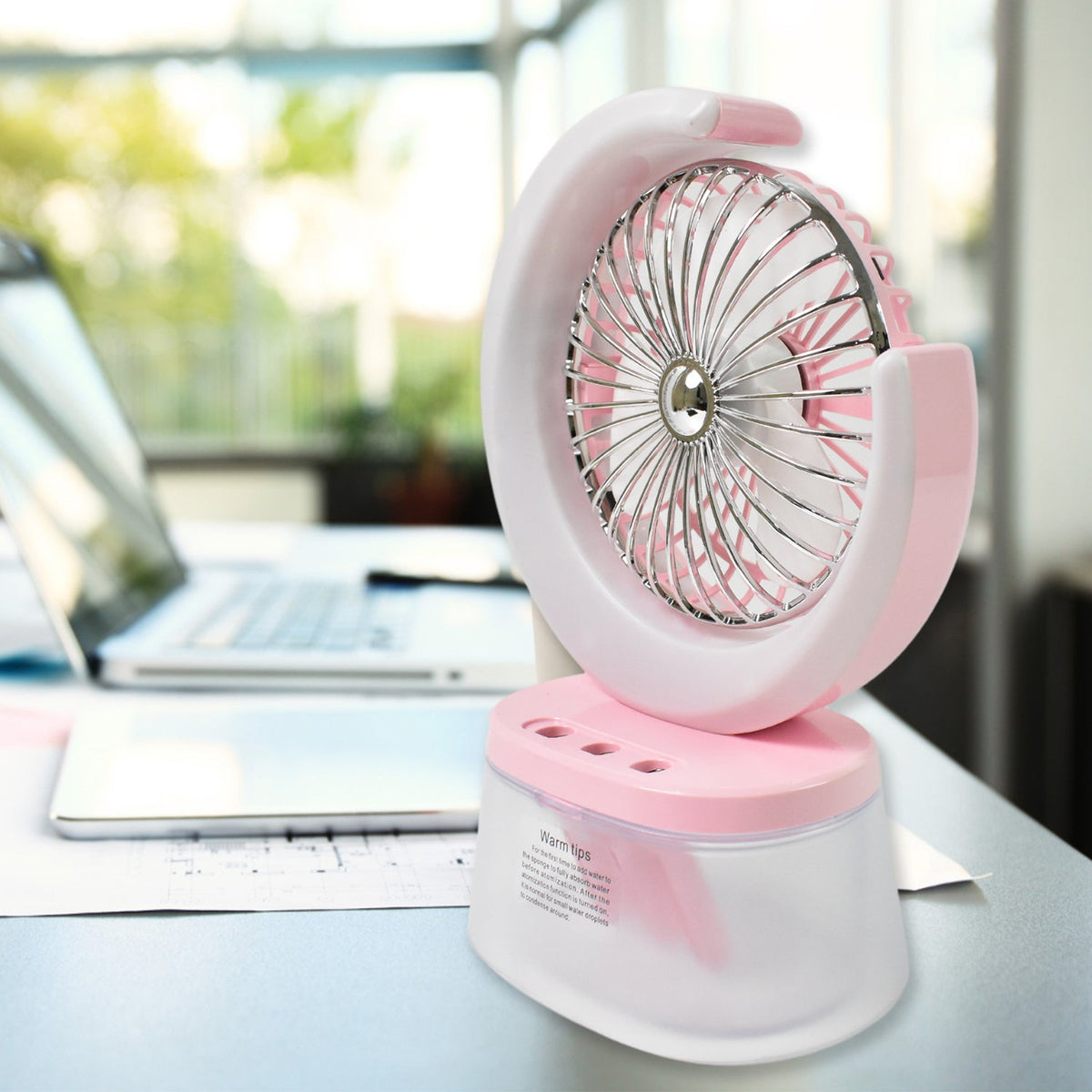 Portable humidifying fan releasing fine mist for cooling and skin moisturization.